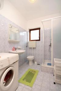 uma casa de banho com uma máquina de lavar roupa e um lavatório em Apartments by the sea Ugljan - 846 em Ugljan
