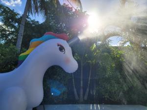 a unicorn statue in a park with the sun in the background at Casa806 Men Only Guest House in Fort Lauderdale