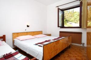 a bedroom with a bed and a window at Apartments by the sea Savar, Dugi otok - 892 in Brbinj