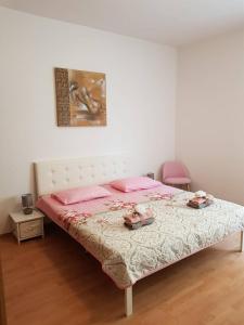 a bedroom with a bed with pink sheets and a pink chair at Apartments by the sea Sali, Dugi otok - 890 in Sali