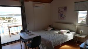 Schlafzimmer mit einem Bett, einem Tisch und einem Fenster in der Unterkunft Apartments by the sea Sali, Dugi otok - 890 in Sali