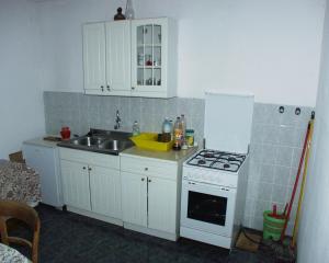 a kitchen with white cabinets and a sink and a stove at Secluded fisherman's cottage Krknata, Dugi otok - 888 in Žman
