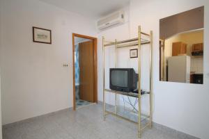 a room with a tv on a stand with a mirror at Apartments with a parking space Sali, Dugi otok - 872 in Sali