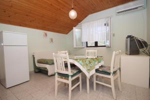 a kitchen with a table and two chairs and a refrigerator at Apartments with a parking space Sali, Dugi otok - 872 in Sali