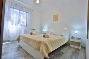 a white bedroom with a bed with two towels on it at Apartments with a parking space Sutivan, Brac - 752 in Sutivan