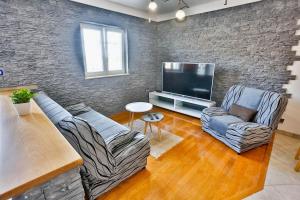 a living room with two couches and a flat screen tv at Apartments with a parking space Sutivan, Brac - 752 in Sutivan