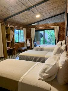 a room with four beds in a room with windows at Pacha Eco Lodge Glamping & Hotel in Archidona