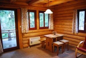 une chambre avec une table et des chaises dans une cabane en rondins dans l'établissement Boróka Apartmanházak - Kakukk House, à Velem