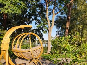 a yellow swing in a park with trees at Waldhotel am See Berlin-Schmöckwitz in Berlin