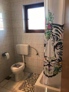 a bathroom with a tiger shower curtain with a toilet at Apartments by the sea Brodarica, Sibenik - 919 in Brodarica