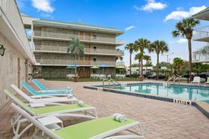 a swimming pool with lounge chairs next to a building at Royal 1 in Kissimmee