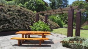a picnic table and a bench in a garden at Bush Line Lodge in Motueka
