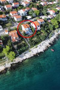 an island with a house in the middle of the water at Apartment Seget Vranjica 1051b in Seget Vranjica
