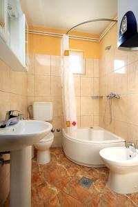 a bathroom with a tub and a toilet and a sink at Apartment Seget Vranjica 1051b in Seget Vranjica