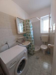 a bathroom with a washing machine and a toilet at Apartments by the sea Stanici, Omis - 1031 in Tice +29 photos