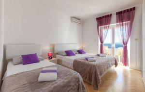 - une chambre avec 2 lits dotés d'oreillers violets et d'une fenêtre dans l'établissement Apartments by the sea Pisak, Omis - 1001, à Pisak