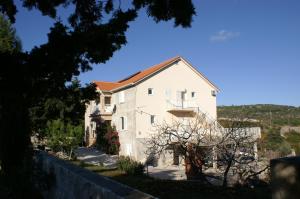 a white house with a fence in front of it at Apartments and rooms with parking space Sumartin, Brac - 757 in Sumartin