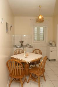 a kitchen with a table and chairs in a room at Apartments and rooms with parking space Sumartin, Brac - 757 in Sumartin