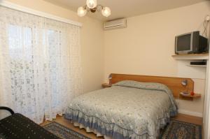 a bedroom with a bed and a tv and a window at Apartments and rooms with parking space Sumartin, Brac - 757 in Sumartin