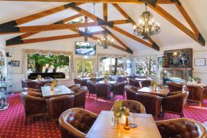 a restaurant with wooden tables and chairs and a chandelier at Black Gold Motel in Wallerawang