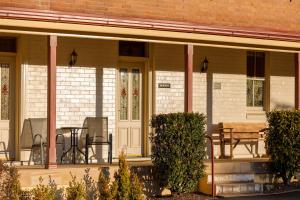 een veranda van een huis met een tafel en stoelen bij Black Gold Motel in Wallerawang