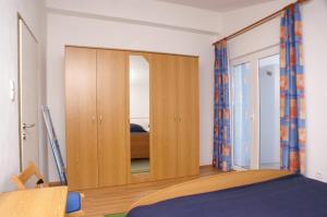 um quarto com um armário de madeira com um espelho em Apartment Tisno 814b em Tisno