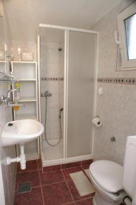 uma casa de banho com um chuveiro, um WC e um lavatório. em Apartment Tisno 814b em Tisno