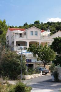 a large white house on top of a hill at Apartments by the sea Postira, Brac - 705 in Postira