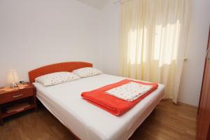 a bedroom with a bed with a red blanket on it at Apartments by the sea Postira, Brac - 705 in Postira