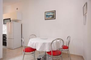 a kitchen with a table with chairs and a refrigerator at Apartments by the sea Postira, Brac - 705 in Postira
