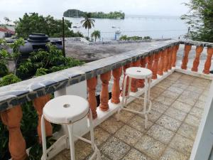 a balcony with two stools and a view of the ocean at Studio Centrally located, 50 mts from El Malecón. in Santa Bárbara de Samaná