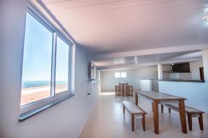 comedor con mesa y vistas a la playa en Souza Reis Apart - Unidade 1, en São Thomé das Letras