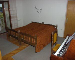a bedroom with a wooden bed and a piano at Apartments by the sea Postira, Brac - 738 in Postira