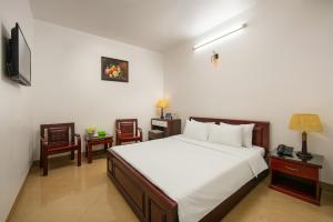 Dormitorio con cama, escritorio y TV en MIA SEN VỌNG HOTEL, en Hanói