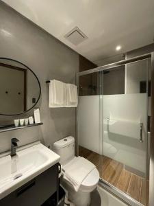 uma casa de banho com um WC, um lavatório e um chuveiro em Acro Residences em Guiguinto