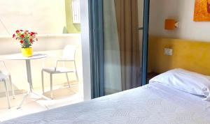 Schlafzimmer mit einem Bett, einem Tisch und Stühlen in der Unterkunft B&B El Gatt in Marotta