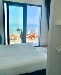 a bedroom with a bed and a view of the ocean at B&B El Gatt in Marotta