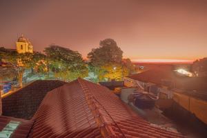 uma vista panorâmica dos telhados de uma cidade ao pôr-do-sol em Souza Reis Apart - Unidade 2 em São Thomé das Letras