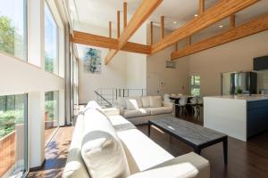 sala de estar con sofá blanco y mesa en Annupuri Onsen Chalet, en Niseko