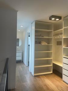 a walk in closet with white cabinets and wood floors at LOFT centrico 11 de Abril in Bahía Blanca