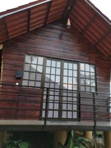 Casa de madera con ventanas y balcón en Villas Rincón del Sur, en Hone Creek