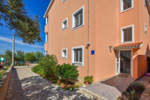 un bâtiment orange dans une rue dans l'établissement Apartments Anita, à Ugrinići