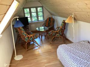 ein Dachzimmer mit Stühlen, einem Tisch und einem Bett in der Unterkunft Holiday home Hadsund CXXXVII in Hadsund