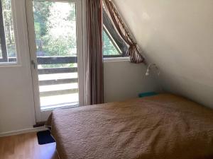 ein Schlafzimmer mit einem Bett und einem großen Fenster in der Unterkunft Holiday home Hadsund CXXXVII in Hadsund