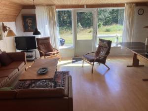 ein Wohnzimmer mit einem Sofa, einem Tisch und Stühlen in der Unterkunft Holiday home Hadsund CXXXVII in Hadsund