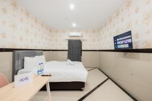 een kleine kamer met een bed en een televisie bij Apik GM 6 Sawah Besar in Jakarta