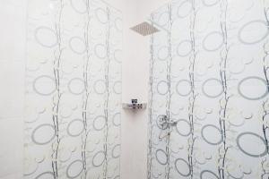 een badkamer met een douchegordijn en een spiegel bij Apik GM 6 Sawah Besar in Jakarta