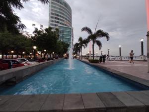 uma fonte no meio de uma rua com um edifício em Suite Riverfront Puerto Santa Ana em Guayaquil