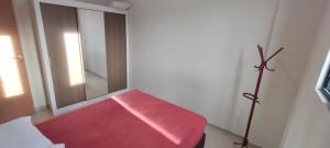 einen roten Stuhl in einem Zimmer mit Spiegel in der Unterkunft Apto 2 quartos em Imbituba Santa Catarina in Imbituba