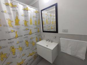 a bathroom with a shower curtain with a toilet and a sink at ALTOS DE CLERMONT in Cordoba +3 photos